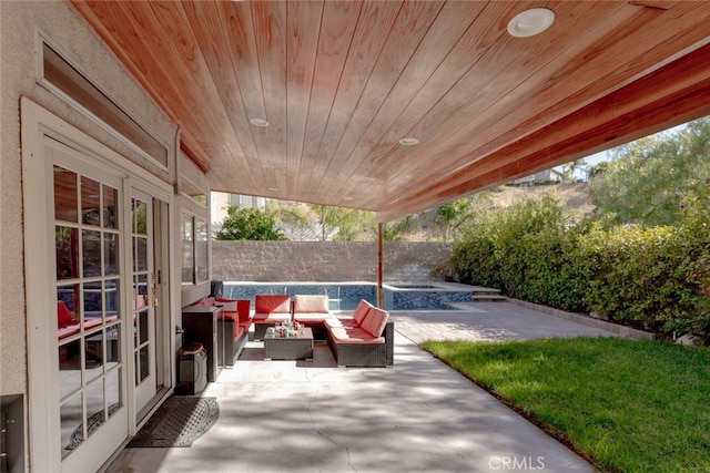 view of patio featuring a fenced backyard, an in ground hot tub, and an outdoor hangout area