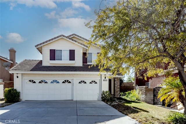 traditional home with a garage, a tiled roof, and concrete driveway