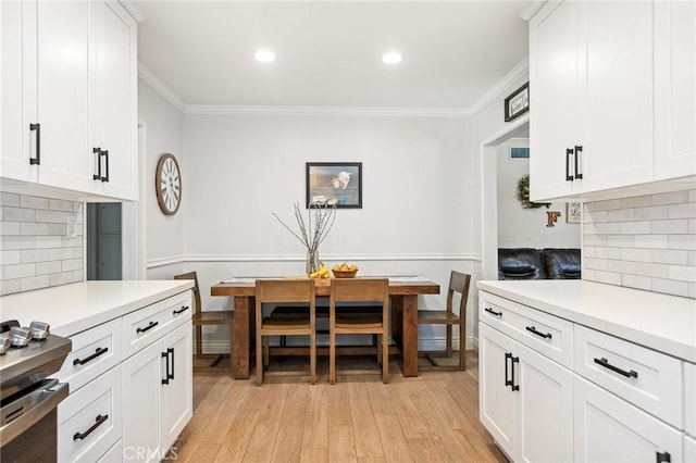 kitchen featuring light countertops, ornamental molding, and backsplash