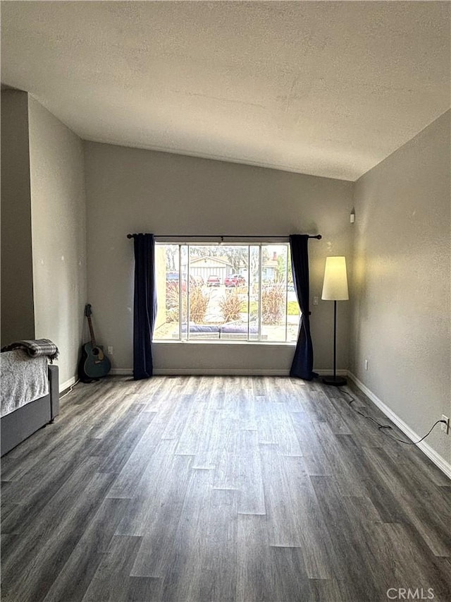 6845 Butte Dr, Riverside, CA 92505 - unfurnished living room featuring wood finished floors, a textured ceiling, baseboards, and lofted ceiling