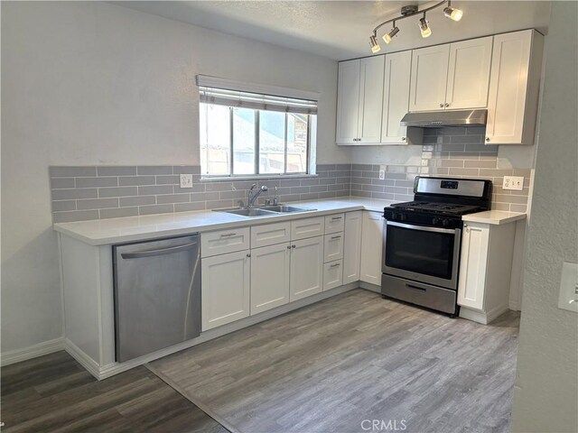 6845 Butte Dr, Riverside, CA 92505 - kitchen with stainless steel appliances, a sink, under cabinet range hood, light countertops, and white cabinets