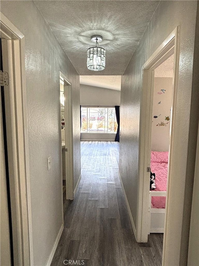 6845 Butte Dr, Riverside, CA 92505 - corridor featuring dark wood-style floors, baseboards, a textured wall, a textured ceiling, and a chandelier