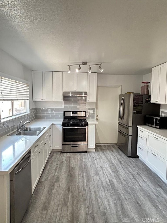 6845 Butte Dr, Riverside, CA 92505 - kitchen with appliances with stainless steel finishes, a sink, a textured ceiling, wood finished floors, and white cabinets