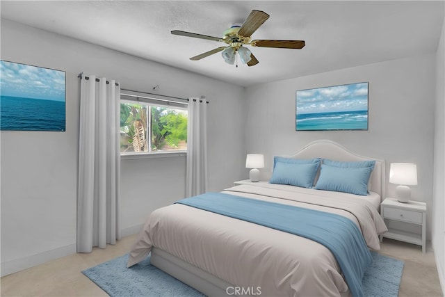 bedroom with baseboards, a ceiling fan, and a water view