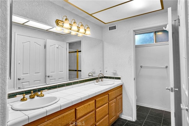 full bathroom featuring a sink, tile patterned floors, double vanity, and visible vents