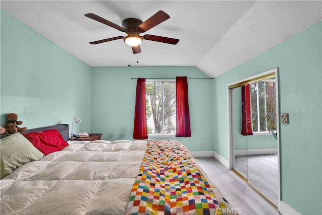 bedroom featuring a closet, a textured ceiling, ceiling fan, and wood finished floors