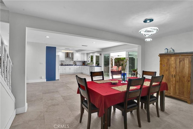 dining area with baseboards, recessed lighting, a chandelier, and stairs