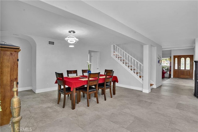 dining space featuring baseboards, stairs, and visible vents