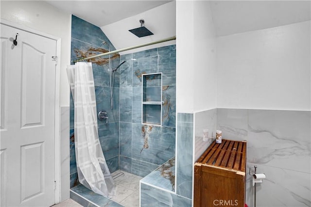 bathroom featuring tile walls, vaulted ceiling, and tiled shower