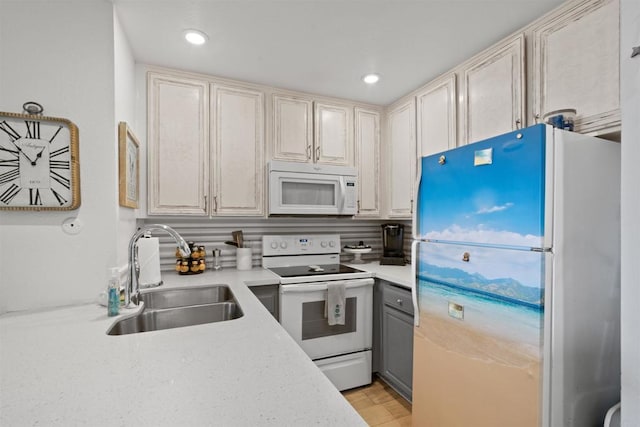 kitchen with a sink, light countertops, recessed lighting, and white appliances