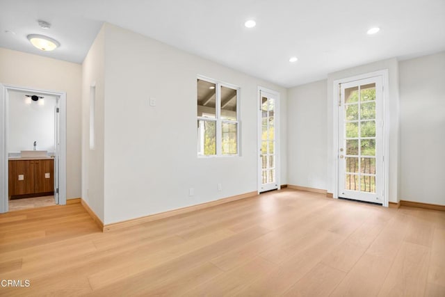 spare room featuring baseboards, recessed lighting, and light wood finished floors