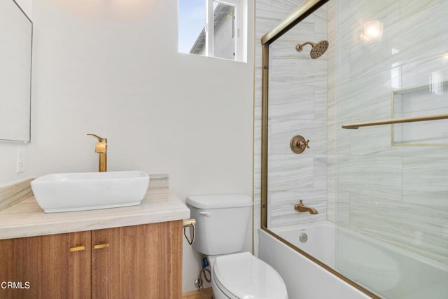 bathroom with vanity, combined bath / shower with glass door, and toilet