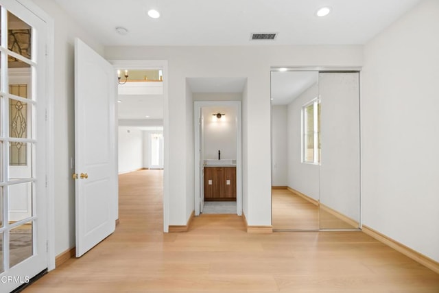 unfurnished bedroom with a notable chandelier, light wood-style flooring, recessed lighting, baseboards, and visible vents