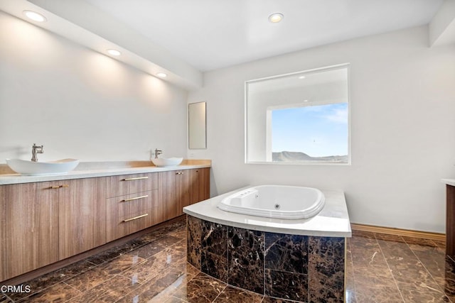 full bathroom featuring double vanity, a sink, a whirlpool tub, and recessed lighting