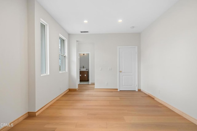 unfurnished bedroom featuring baseboards, light wood finished floors, and visible vents