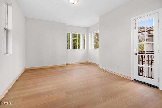unfurnished room featuring baseboards and light wood-type flooring