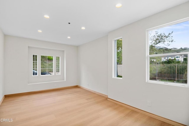 spare room featuring recessed lighting, light wood-style floors, and a healthy amount of sunlight