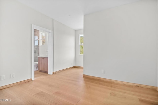 unfurnished room featuring baseboards and light wood-style flooring