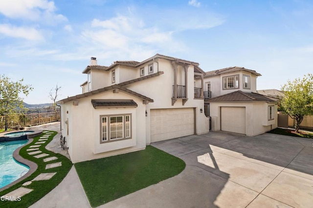 mediterranean / spanish home featuring a balcony, stucco siding, a chimney, concrete driveway, and an attached garage