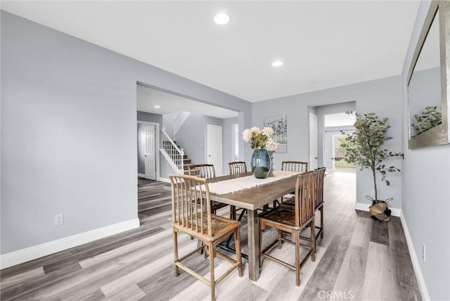 dining space featuring light wood-style flooring, stairs, baseboards, and recessed lighting