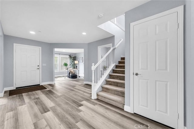 entrance foyer featuring stairway, baseboards, wood finished floors, and recessed lighting