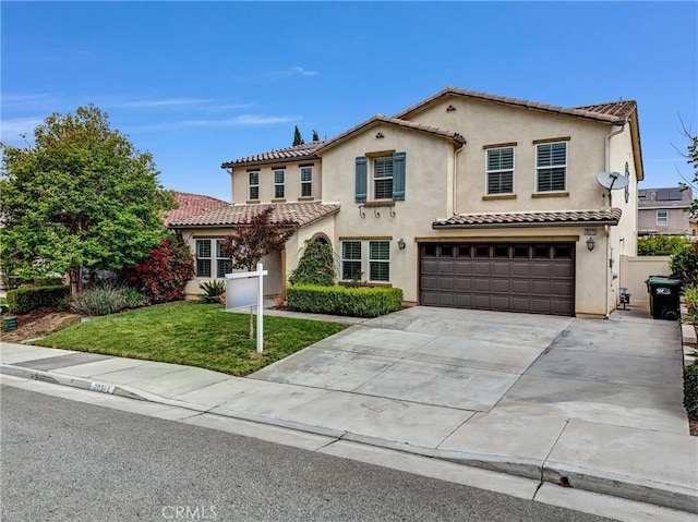 mediterranean / spanish-style home with a garage, a tiled roof, concrete driveway, and stucco siding
