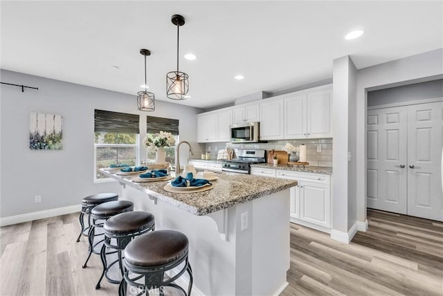 20372 Crooked Branch St, Riverside, CA 92507 - kitchen featuring stainless steel appliances, baseboards, a sink, white cabinets, and recessed lighting