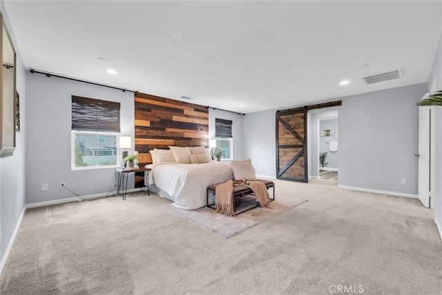 carpeted bedroom featuring a barn door, recessed lighting, baseboards, wooden walls, and multiple windows