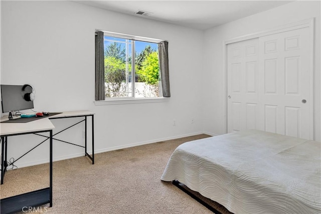 carpeted bedroom featuring baseboards, a closet, and visible vents