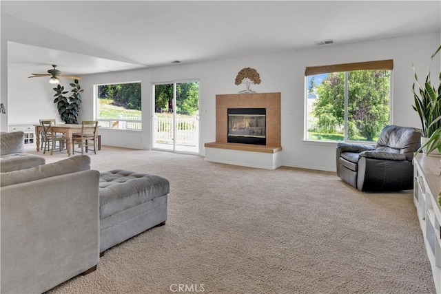 9121 San Diego Rd, Atascadero, CA 93422 - living room featuring plenty of natural light, a fireplace, a ceiling fan, and carpet floors