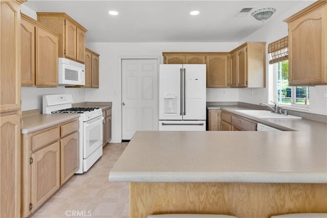 kitchen featuring a sink, light countertops, a peninsula, recessed lighting, and white appliances