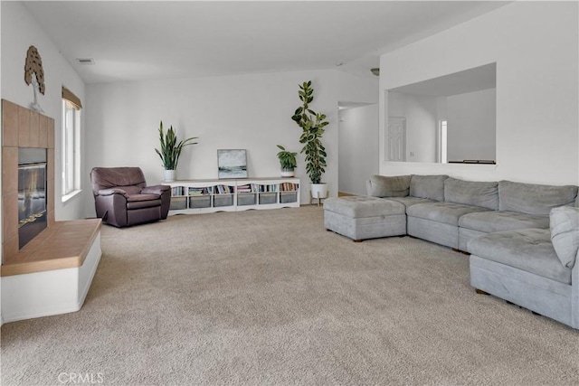 living room featuring carpet floors, a fireplace, and lofted ceiling