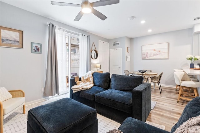 living area with baseboards, ceiling fan, light wood-style flooring, and recessed lighting