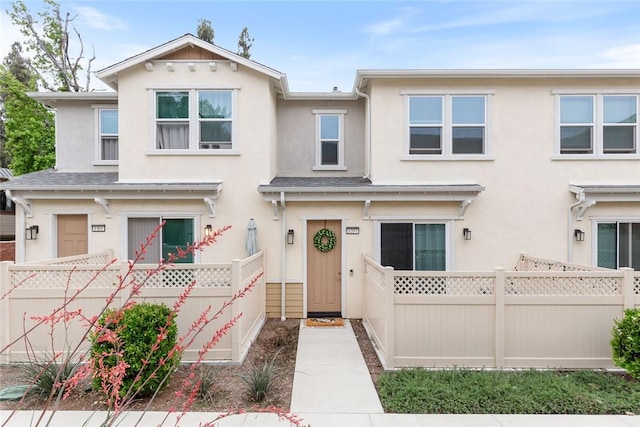 townhome / multi-family property featuring stucco siding and fence