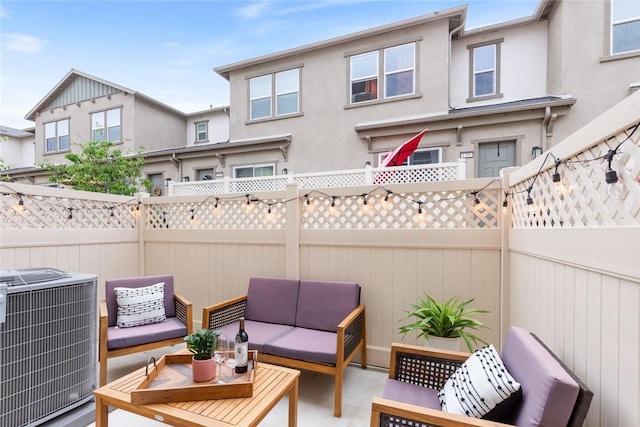 view of patio featuring cooling unit, outdoor lounge area, and fence