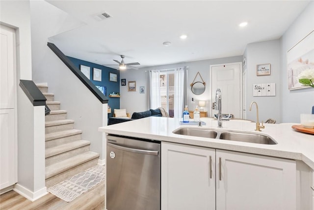 kitchen with stainless steel dishwasher, a sink, ceiling fan, white cabinetry, and light countertops
