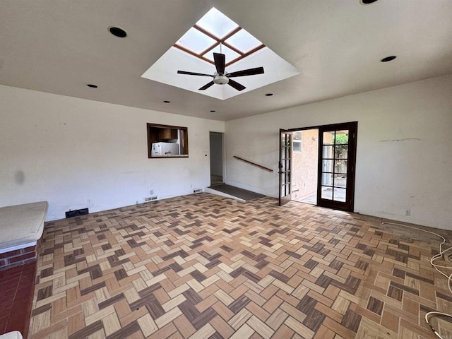 spare room featuring a ceiling fan and a skylight