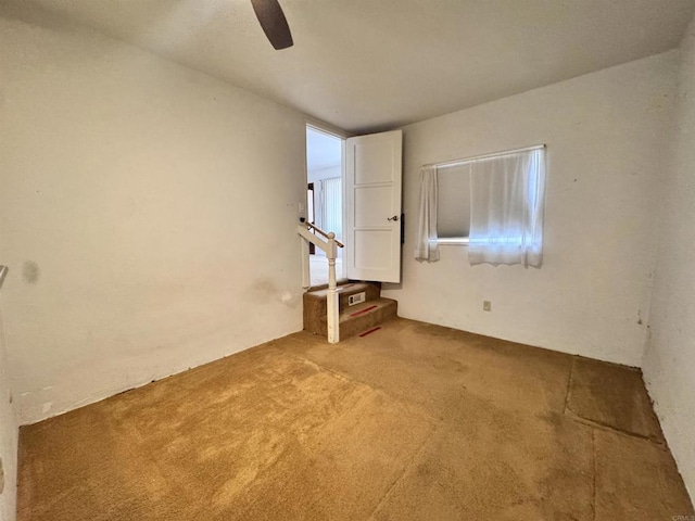 unfurnished room with carpet flooring and a ceiling fan
