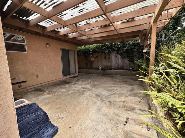 view of patio / terrace featuring a pergola, fence, and a carport