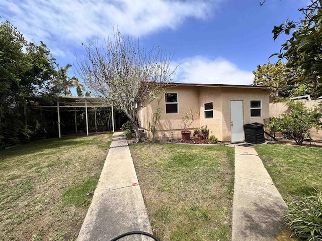 bungalow featuring central air condition unit, an outdoor structure, stucco siding, and a front yard