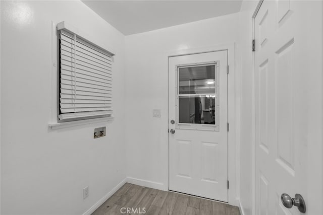 doorway with light wood-style floors and baseboards