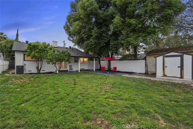 view of yard featuring a storage shed, fence, cooling unit, an outdoor structure, and a patio