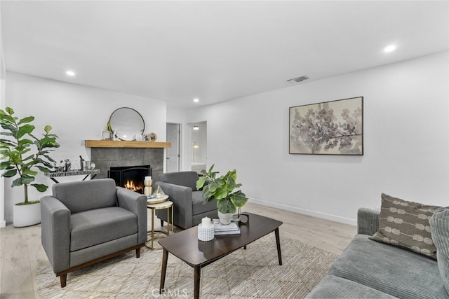 living room with light wood finished floors, recessed lighting, baseboards, a tile fireplace, and visible vents