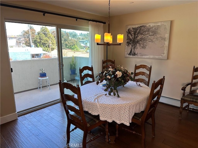 600 Morro Bay Blvd Unit 302, Morro Bay, CA 93442 - dining area featuring baseboards, wood finished floors, a notable chandelier, and baseboard heating