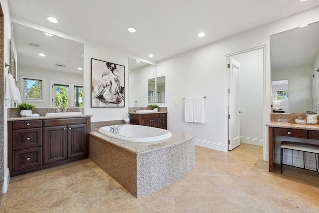 bathroom with recessed lighting, a sink, and a garden tub