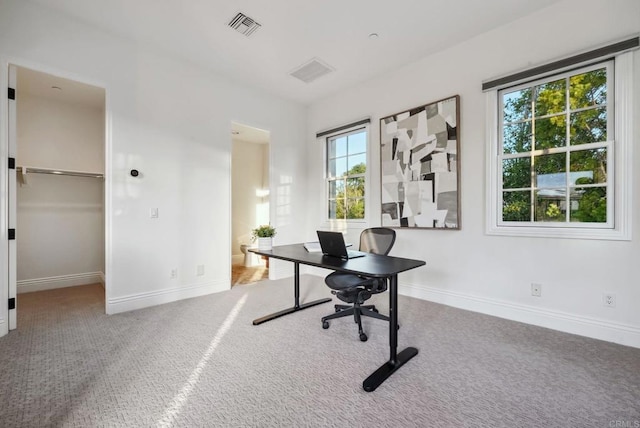 office space featuring carpet flooring, baseboards, and visible vents