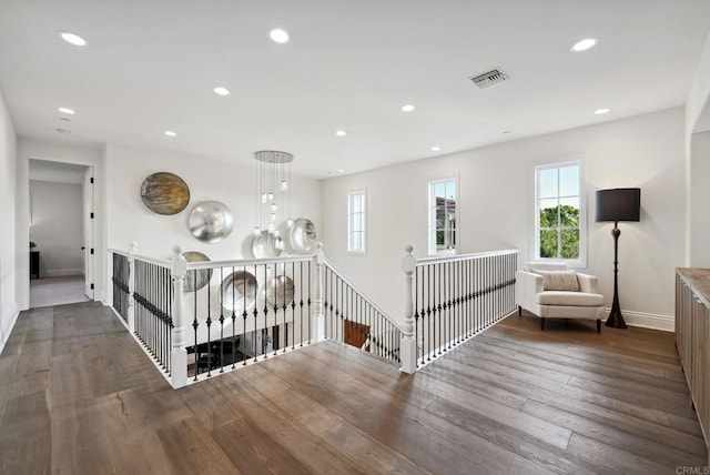 interior space featuring a healthy amount of sunlight, baseboards, wood finished floors, and visible vents