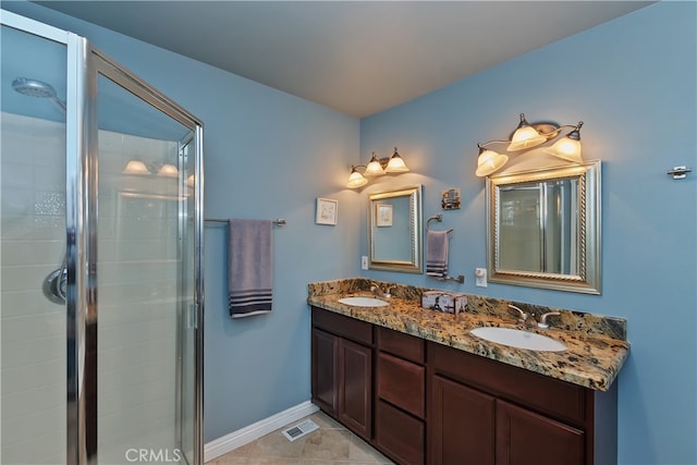 full bath featuring double vanity, a sink, and a stall shower