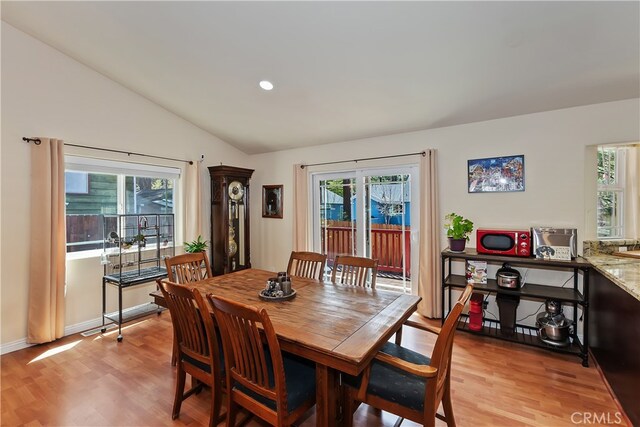 dining space with recessed lighting, baseboards, vaulted ceiling, and light wood-type flooring