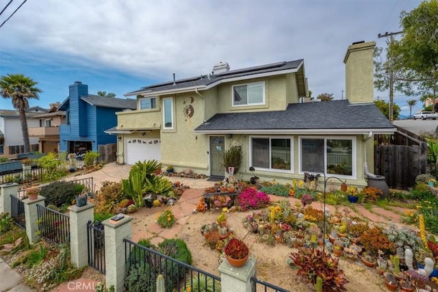 1585 Saratoga Ave, Grover Beach, CA 93433 - view of front of house with stucco siding, roof mounted solar panels, an attached garage, and a chimney